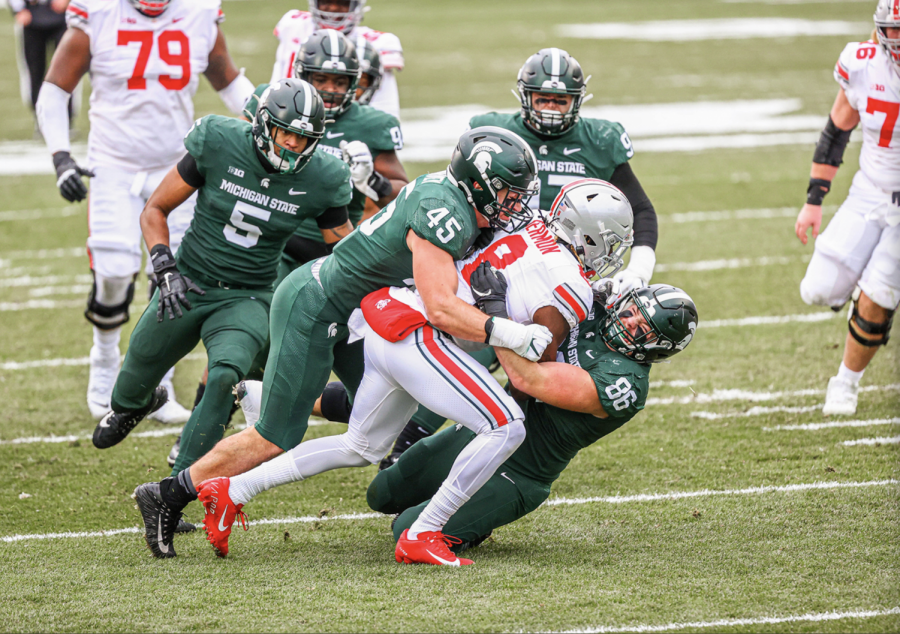 Noah Harvey (45) and Jacub Panasiuk (96) and others combine for a tackle on OSU RB Trey Sermon/ Photo Credit: MSU Athletic Communications


