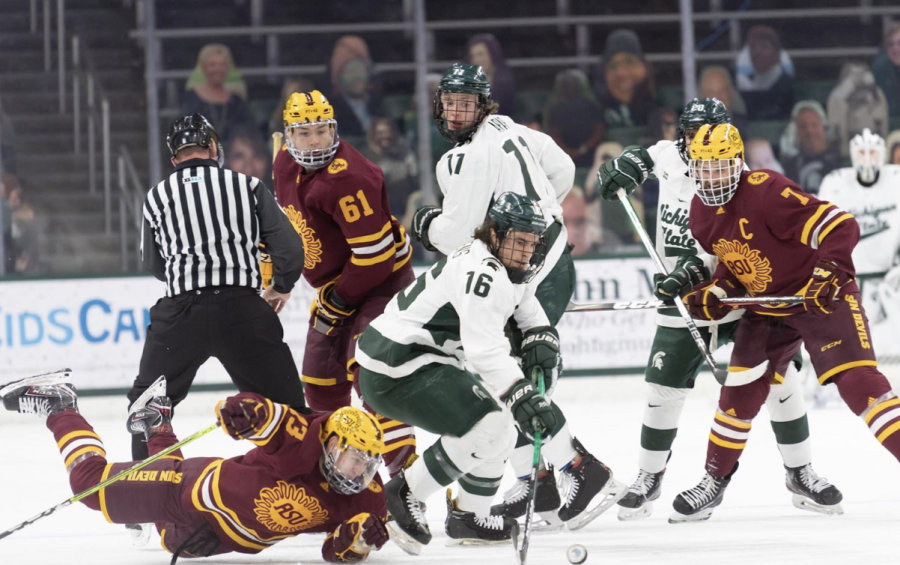 MSU+forward+Brody+Stevens+%2816%29+dives+for+the+puck+amidst+a+sea+of+Arizona+State+players%2F+Photo+Credit%3A+MSU+Athletic+Communications