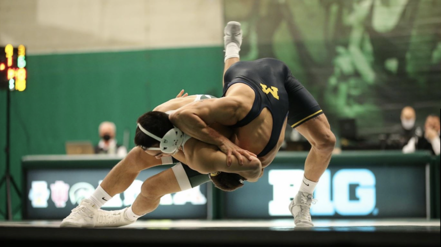 MSU wrestler Peyton Omania tosses a Michigan wrestler to the ground/Photo Credit: Michigan State Athletic Communications 