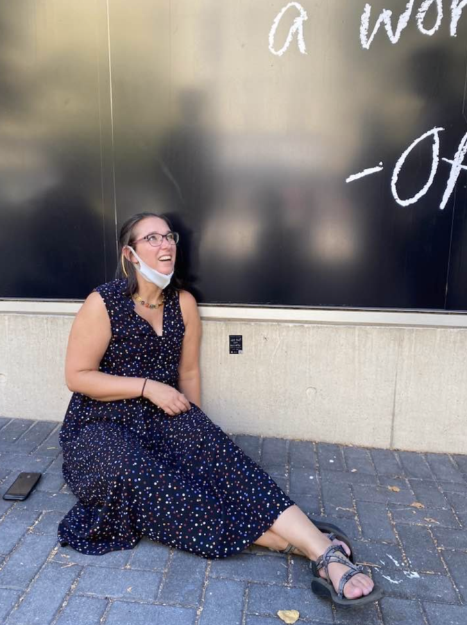 Professor Natalie Phillips sitting on the ground at a disability art exhibition / Photo credit: Natalie Phillips