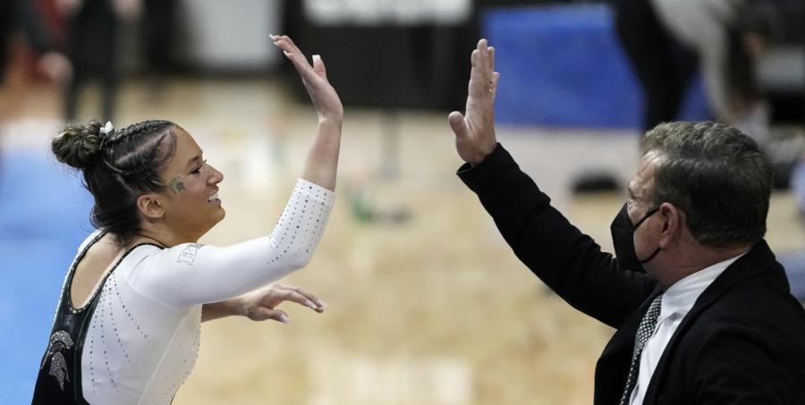 MSU coach Mike Rowe high-fives Skyla Schulte during a 2022 meet/ Photo Credit: MSU Athletic Communications