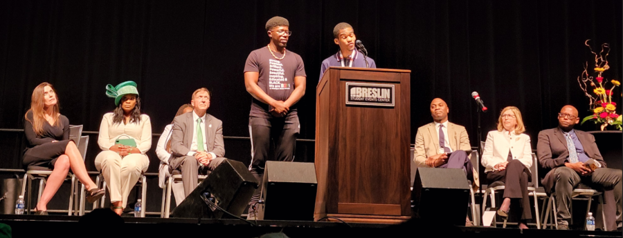 Black Student Alliance Marcus McDaniel Jr. (Right, on podium) and Black Graduate Student Association President Antonio White (Left) address crowd with prominent MSU members behind them.