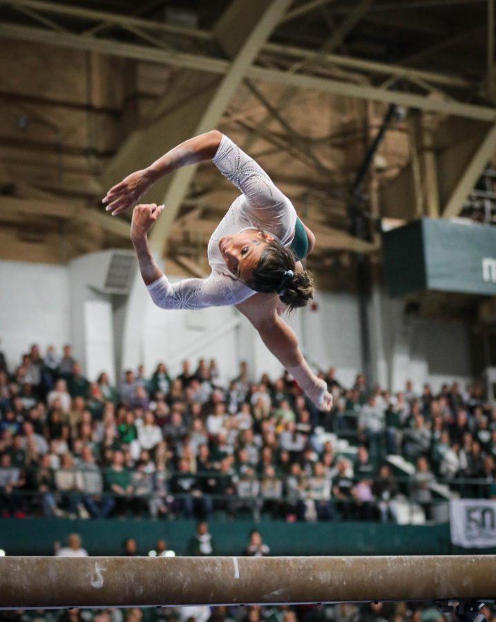 Skyla+Schulte+flips+on+the+beam+during+Michigan+States+197.200-196.975+victory+over+No.+3+Michigan+on+January+22%2C+2023.+Photo+Credit%3A+Sarah+Smith%2FWDBM
