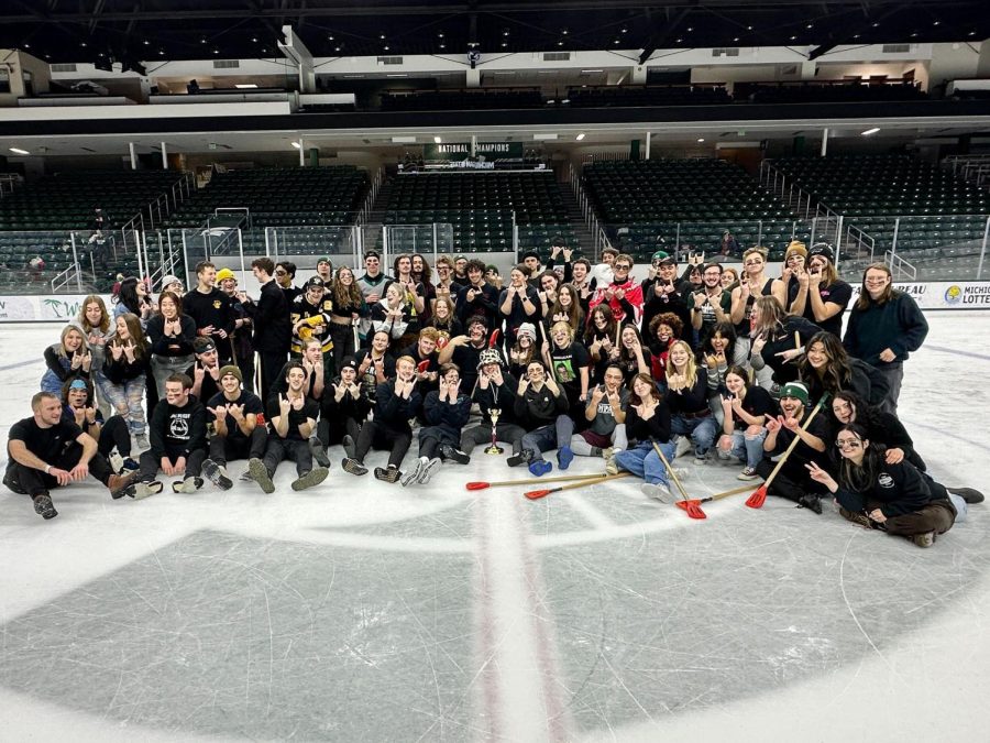 Impact+celebrates+with+the+trophy+at+center+ice+after+a+5-2+victory+in+the+annual+Broomball+showcase.+%2F%2F+Photo+Credit%3A+Jeremy+Whiting