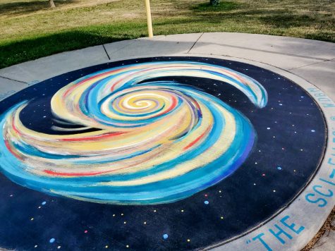 Circular galaxy mural on a concrete stage
