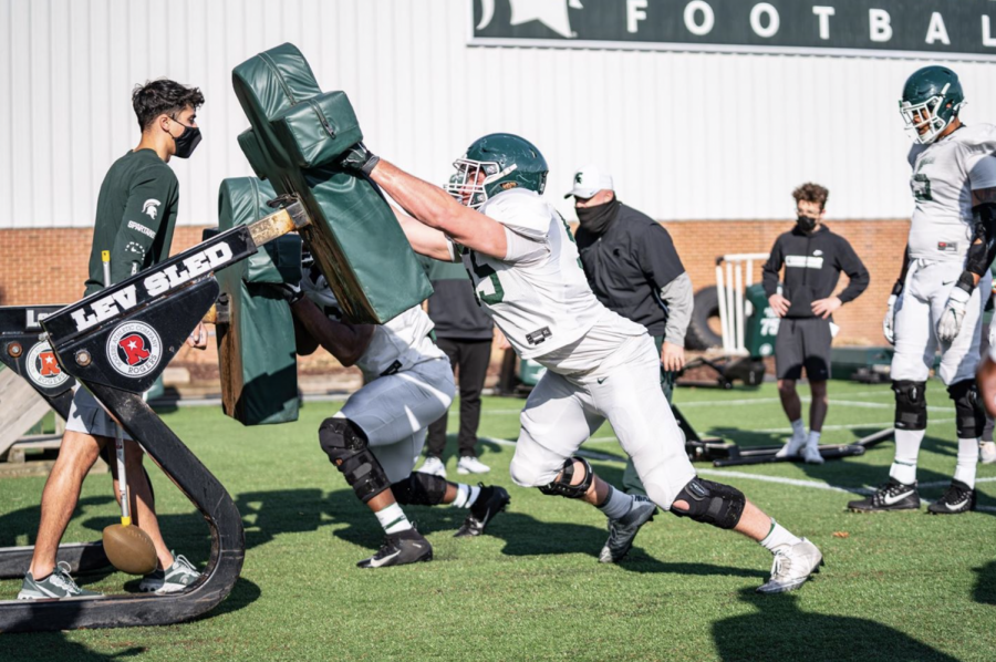 MSU offensive line coach Chris Kapilovic supervises a sled-driving drill during 2021 spring practice/ Photo Credit: MSU Athletic Communications 







