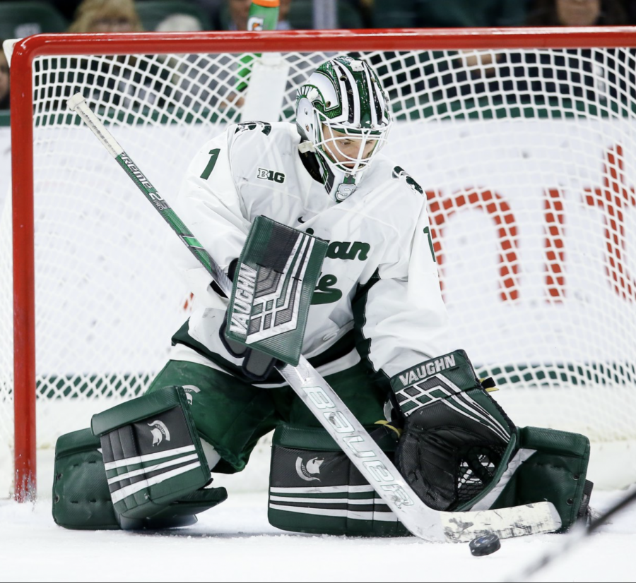 MSU goaltender Drew DeRidder swats away a puck in front of the net/ Photo Credit: MSU Athletic Communications