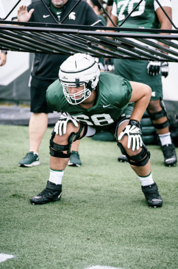 MSU+offensive+lineman+Dan+VanOpstall+stands+underneath+the+o-line+chute+during+2021+fall+practice%2F+Photo+Credit%3A+MSU+Athletic+Communications+
