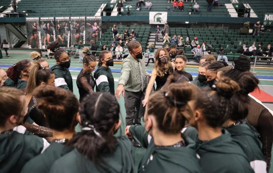 Michigan State womens gymnastics coach Mike Rowe leads his team in a cheer before the Spartans participate in a 2022 meet against Bowling Green/ Photo Credit: MSU Athletic Communications