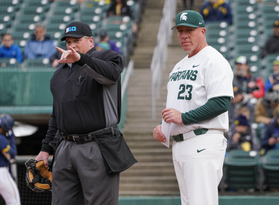 MSU coach Jake Boss stands next to an umpire before the Spartans take on Michigan on April 15, 2022/ Photo Credit: MSU Athletic Communications 