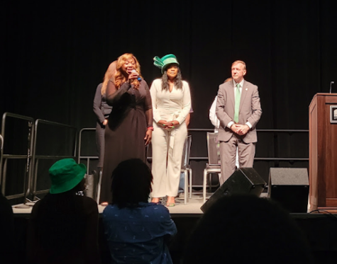 Lanette Hester stands in front of MSU Trustee Rema Vassar and MSU President Samuel L. Stanley Jr., singing "Lift Every Voice and Sing."