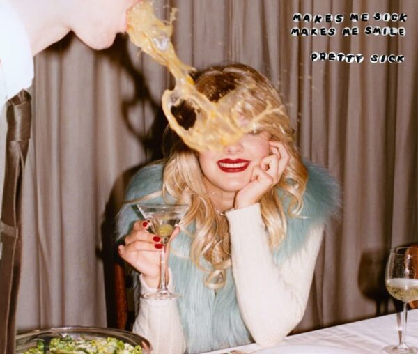 A woman at a dinner table with a still image of a man vomiting onto the table