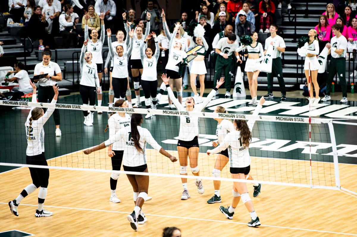 MSU sophomore middle blocker Nil Okur (6) celebrates with teammates after scoring a point against Michigan on Wednesday, October 18, 2023 at the Breslin Center.