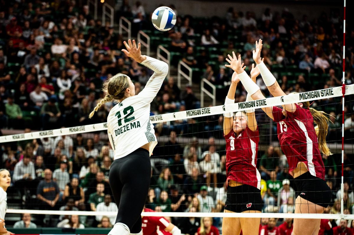 MSU sophomore middle blocker Evie Doezema rises to hit the ball against Wisconsin on Friday, October 27, 2023 at the Breslin Center.