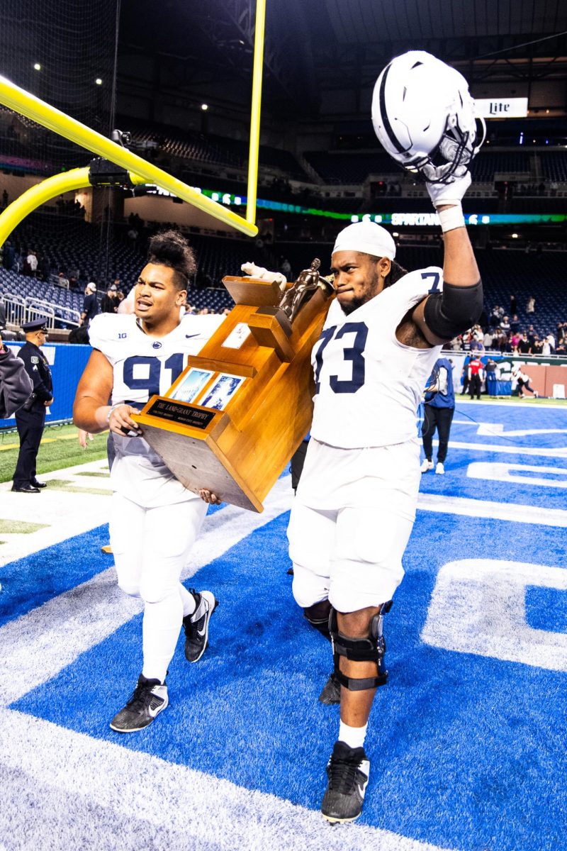 Penn+State+redshirt+senior+defensive+tackle+Dvon+Ellies+%2891%29+and+redshirt+senior+offensive+lineman+Caedan+Wallace+hoist+the+Land+Grant+Trophy+after+a+42-0+victory+over+MSU+on+Friday%2C+November+24%2C+2023+at+Ford+Field.