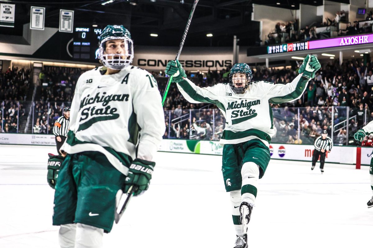 MSU fifth year forward Nicolas Müller (left) and freshman defender Artyom Levshunov celebrate a goal against Wisconsin on Friday, November 17, 2023 at Munn Ice Arena.