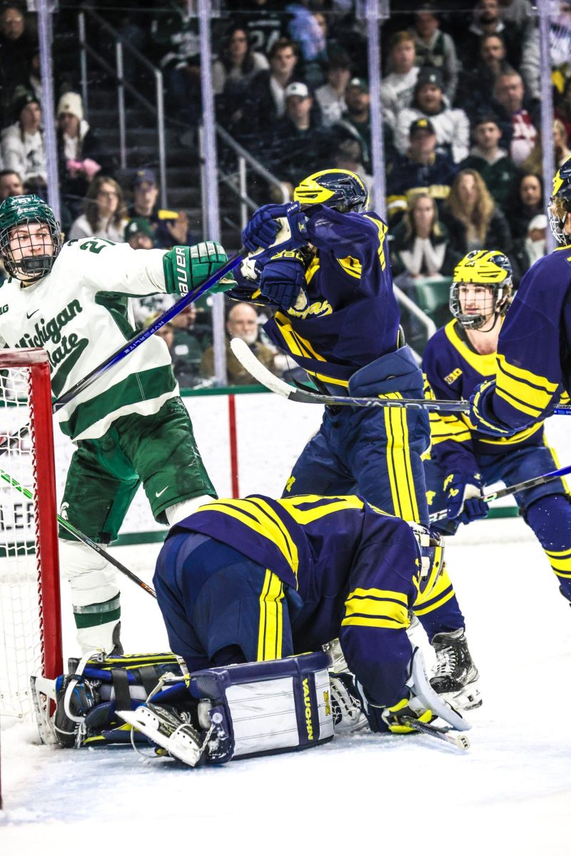 MSU junior forward Red Savage (left) gets tangled with a Michigan defender on Friday, Jan. 19, 2024 at Munn Ice Arena.