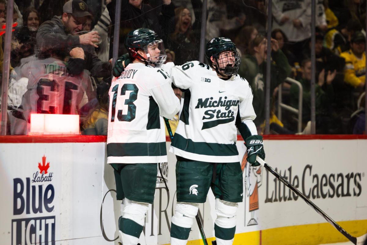 The Spartans hoist the Duel in the D trophy after a 3-2 victory over Michigan on Saturday, Feb. 11, 2024 at Little Caesars Arena in Detroit. (Avery Kotel)