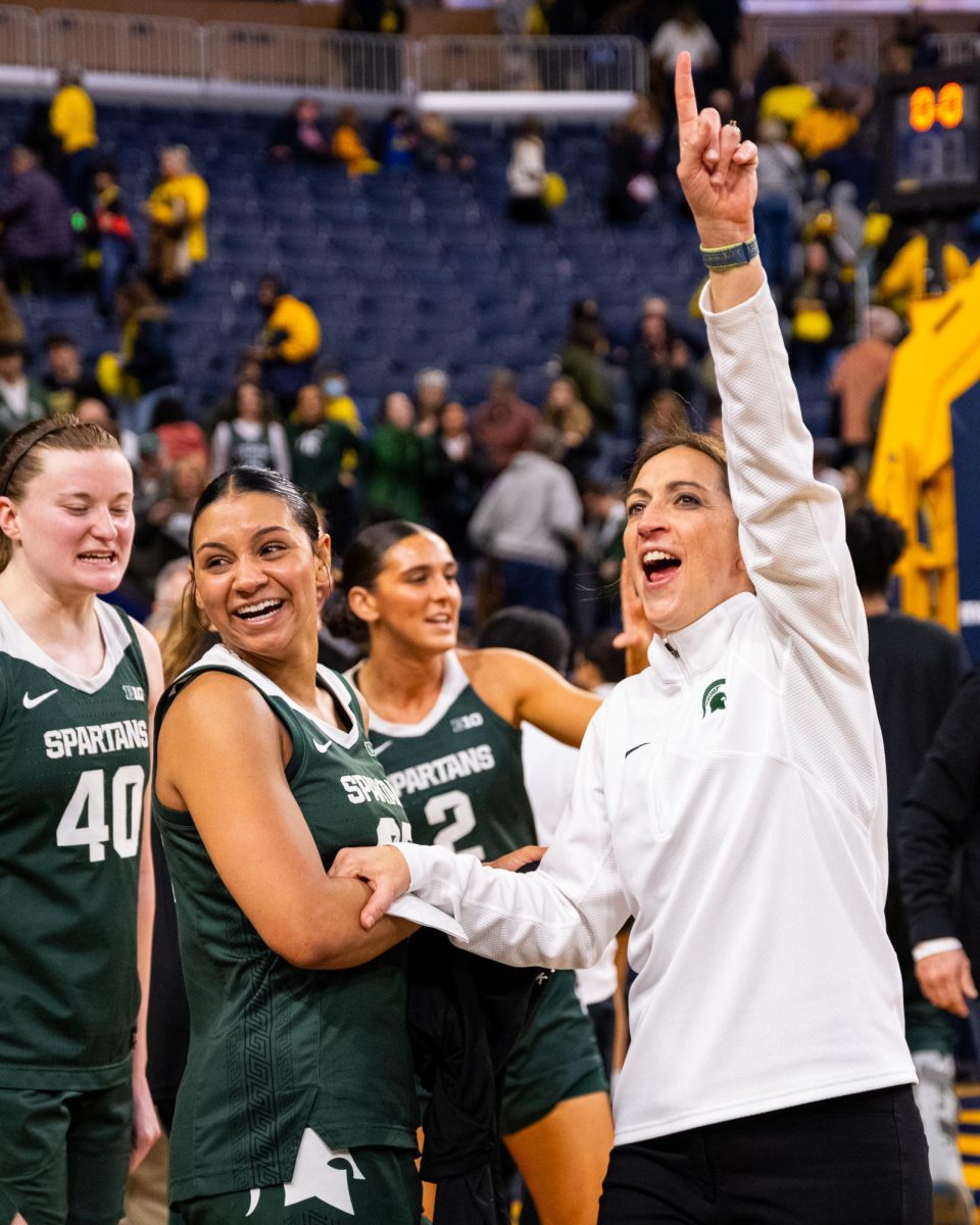 MSU Head Coach Robyn Fralick celebrates with graduate guard Moira Joiner and graduate forward Julia Ayrault in front of Spartan fans in attendance against Michigan on Sunday, Feb. 18, 2024 at the Crisler Center in Ann Arbor.