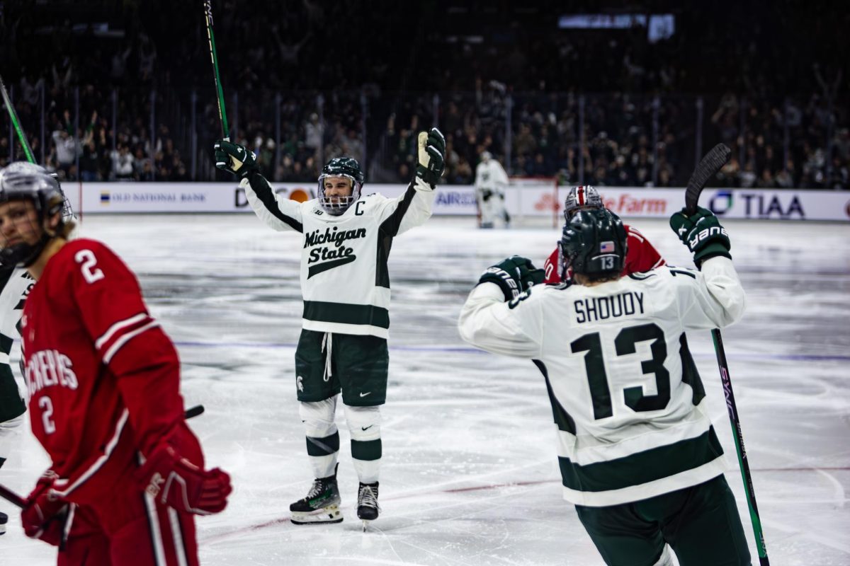 MSU senior defender Nash Nienhuis (middle) celebrates a goal with sophomore forward Tiernan Shoudy (13) during a 2-1 victory over Ohio State in the B1G Tournament semifinal on Saturday, Mar. 16, 2024 at Munn Ice Arena in East Lansing. (Photo by Avery Kotel)