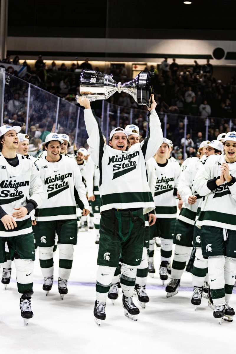 The Spartans hoist the B1G Tournament trophy after a 5-4 overtime victory over Michigan on Saturday, Mar. 23, 2024 at Munn Ice Arena. (Avery Kotel)