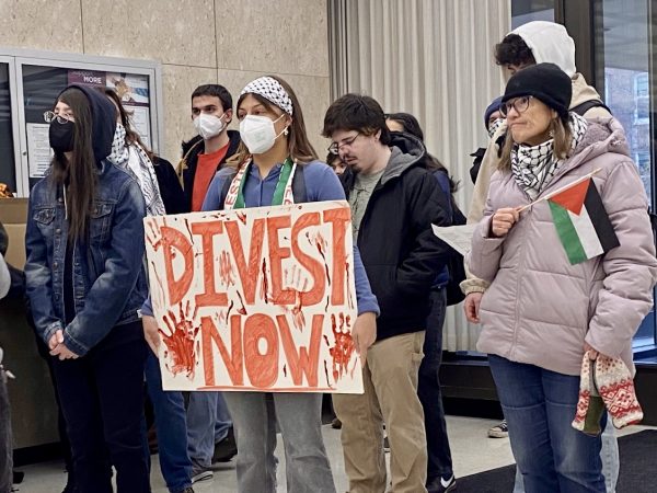 A student holds a "divest now," poster inside the Hannah Administration Building. The coalition occupied the building until MSU police forced them out, arresting 19. Photo credit: Fletcher Wasnich/WDBM